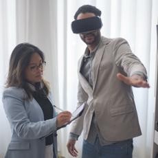 Two business professionals exploring virtual reality technology indoors. Collaboration in progress.